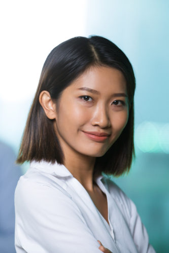 Closeup portrait of content beautiful young Asian woman looking at camera